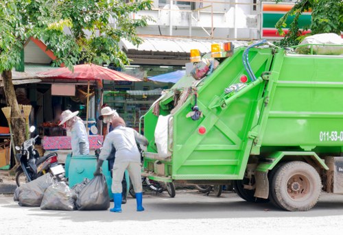 Team performing safe waste removal with high-visibility clothing and protective gear